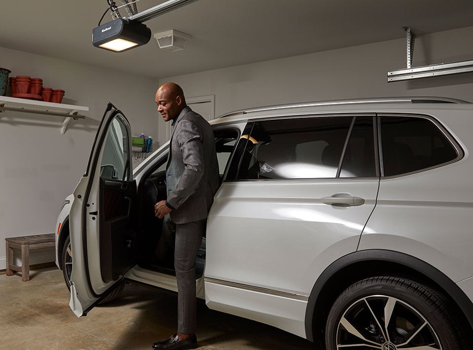 man exiting car under kwikset garage door opener